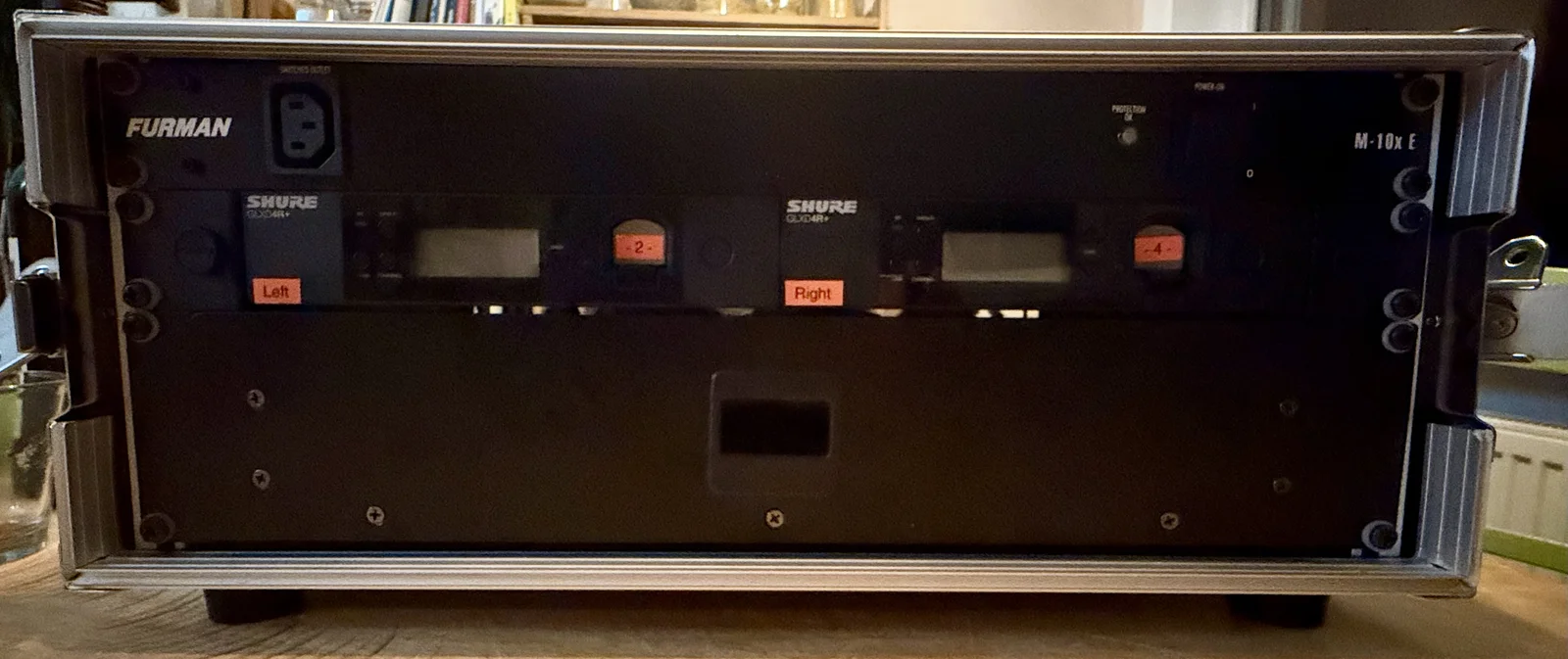 Vorderseite des Rack-Koffers mit Furman-Stromverteilung oben, zwei Shure-Funkempfängern in der Mitte und Schublade darunter.